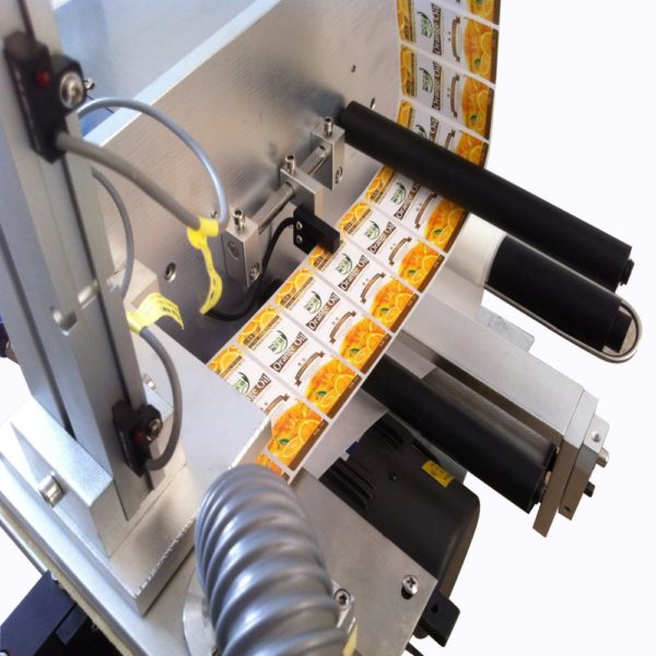 Semi automatic labelling machine for self adhesive labels on square containers.
